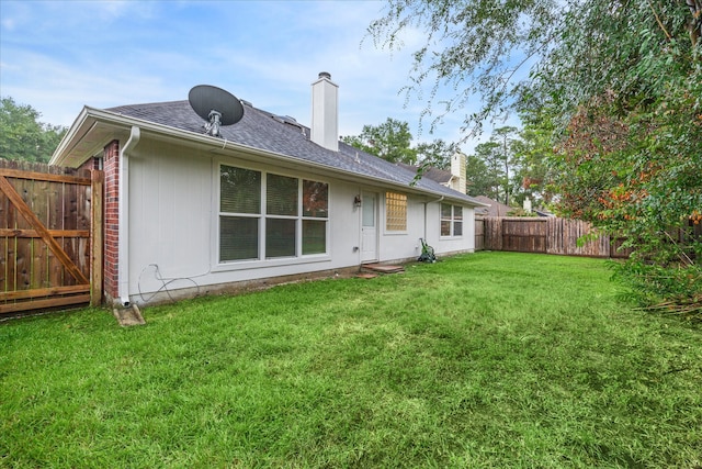 rear view of house featuring a lawn