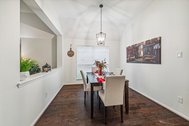 dining space with lofted ceiling, a notable chandelier, and dark hardwood / wood-style flooring