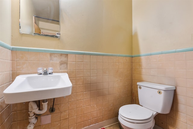 bathroom featuring toilet and tile walls