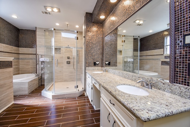 bathroom with vanity, tile walls, and shower with separate bathtub