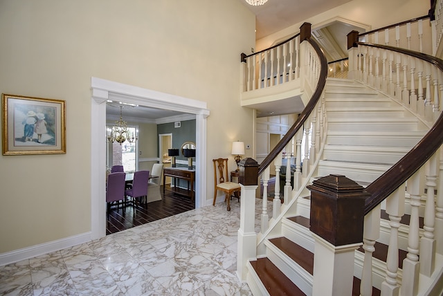 entrance foyer featuring a towering ceiling, a notable chandelier, and ornamental molding