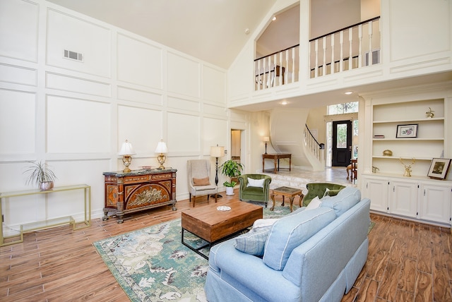 living room with high vaulted ceiling, wood-type flooring, and built in features