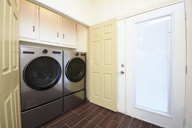 washroom featuring dark wood-type flooring, independent washer and dryer, and cabinets