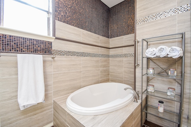 bathroom featuring a relaxing tiled tub and tile walls