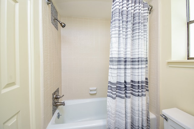 bathroom featuring toilet and shower / bathtub combination with curtain