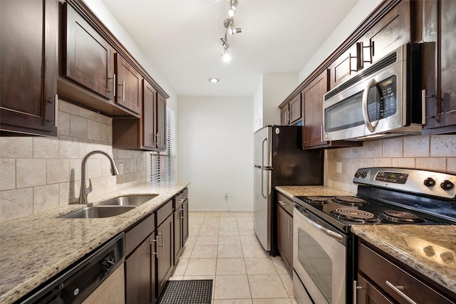2255 Braeswood Park Dr Unit 184, Houston, TX 77030 - kitchen with light stone counters, a sink, appliances with stainless steel finishes, dark brown cabinets, and baseboards