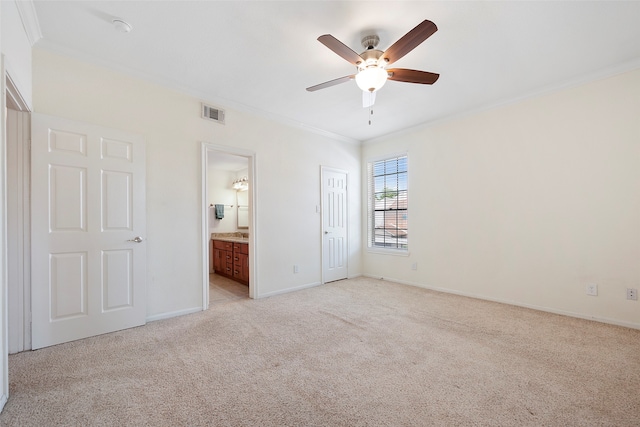 unfurnished bedroom featuring ensuite bathroom, light carpet, crown molding, and ceiling fan