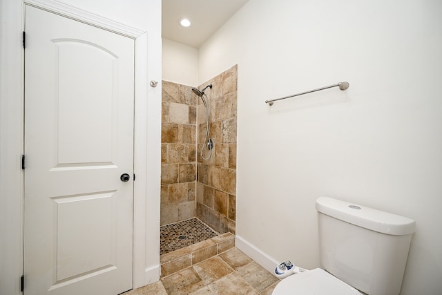 bathroom with a tile shower and toilet