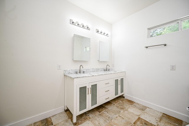 30626 Logger Ln, Magnolia, TX 77355 - bathroom featuring baseboards, double vanity, and stone tile flooring