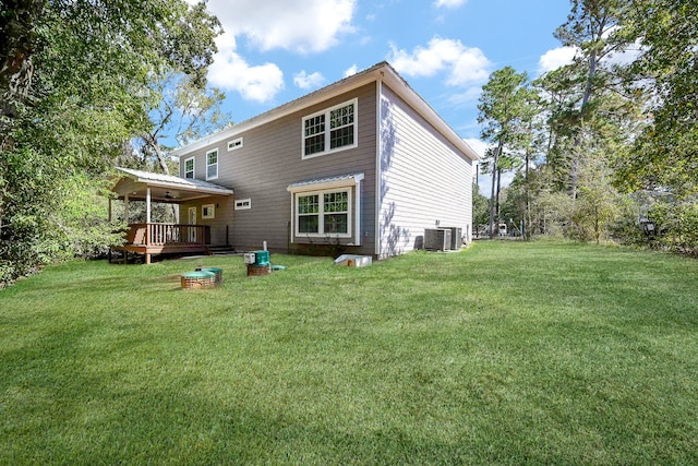 rear view of property featuring a deck, a lawn, and central AC unit