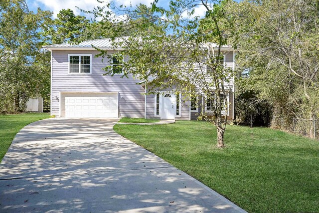 30626 Logger Ln, Magnolia, TX 77355 - view of front of home with a garage, concrete driveway, a front yard, metal roof, and a standing seam roof