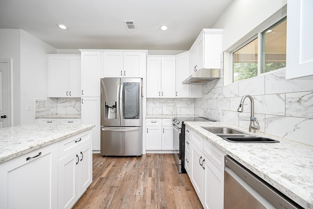 30626 Logger Ln, Magnolia, TX 77355 - kitchen with stainless steel appliances, a sink, light wood-type flooring, white cabinetry, and recessed lighting