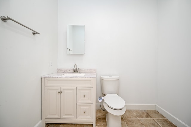 bathroom with vanity, toilet, and tile patterned flooring