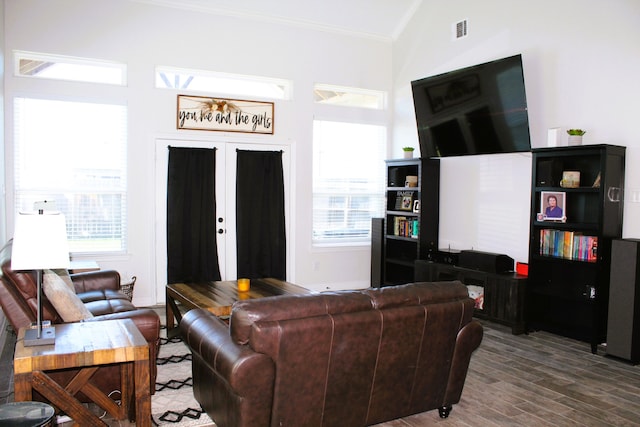 living room featuring french doors, crown molding, hardwood / wood-style flooring, and vaulted ceiling