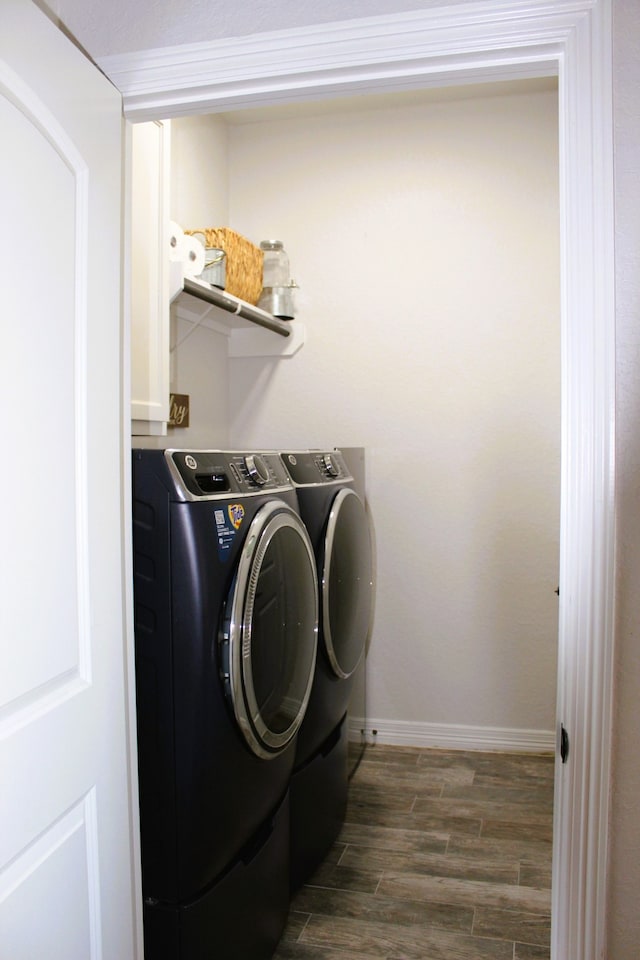 laundry room featuring washing machine and clothes dryer and dark hardwood / wood-style flooring