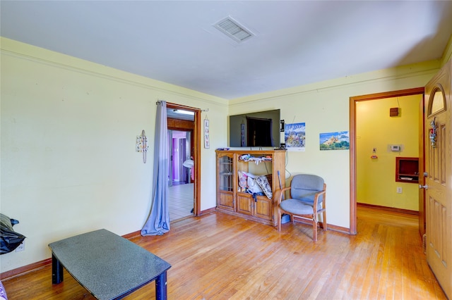 sitting room featuring light hardwood / wood-style floors and crown molding