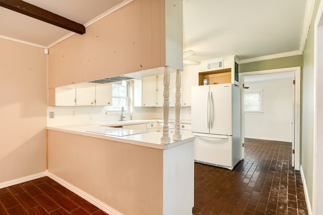 kitchen with white cabinets, kitchen peninsula, a healthy amount of sunlight, and white refrigerator