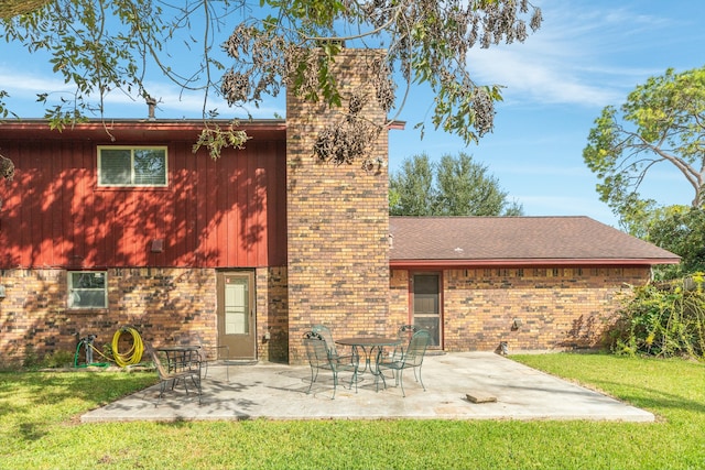 back of house featuring a patio area and a lawn