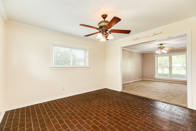 empty room featuring ornamental molding, dark colored carpet, ceiling fan, and plenty of natural light