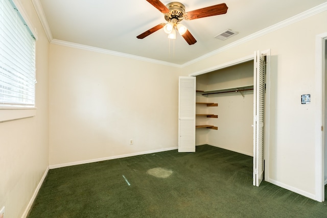 unfurnished bedroom with ceiling fan, a closet, dark colored carpet, crown molding, and golf simulator