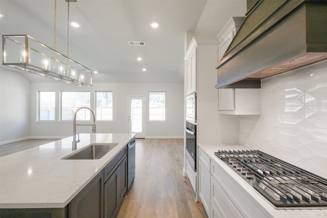 kitchen featuring white cabinetry, stainless steel appliances, sink, and custom exhaust hood