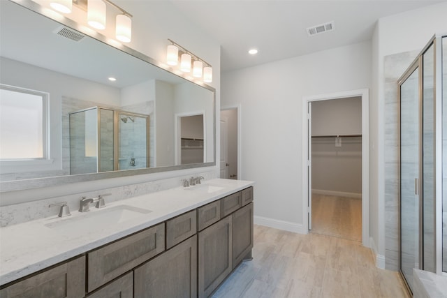 bathroom with vanity, a shower with shower door, and hardwood / wood-style flooring