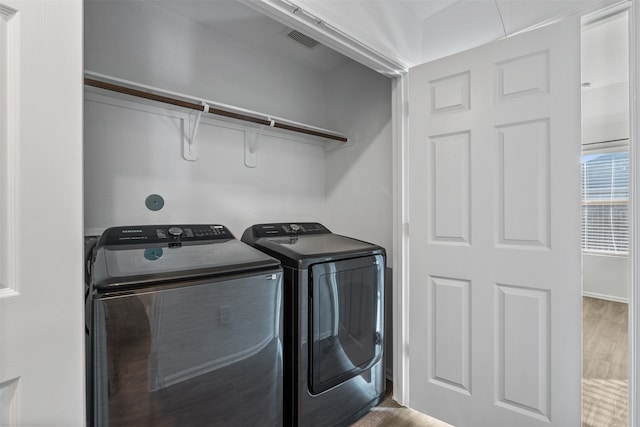 washroom featuring hardwood / wood-style floors and separate washer and dryer