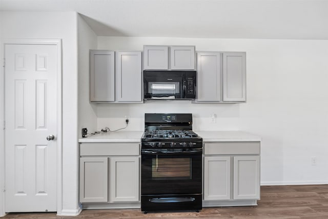 kitchen with hardwood / wood-style flooring, black appliances, and gray cabinetry