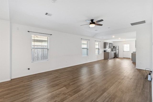 unfurnished living room with ceiling fan, dark hardwood / wood-style floors, and plenty of natural light