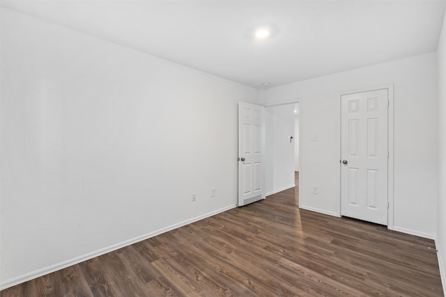 unfurnished room with dark wood-type flooring