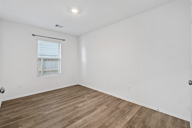 spare room featuring wood-type flooring