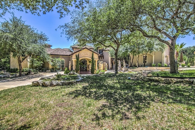 mediterranean / spanish-style home with a front lawn