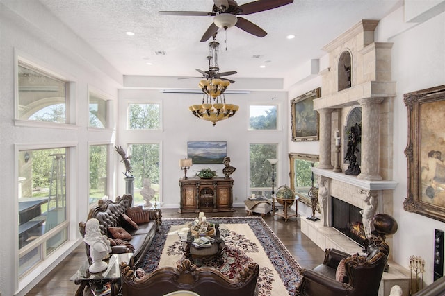 9469 Canyon Mist, Helotes, TX 78023 - living room featuring plenty of natural light, a premium fireplace, a textured ceiling, dark wood-style floors, and a high ceiling