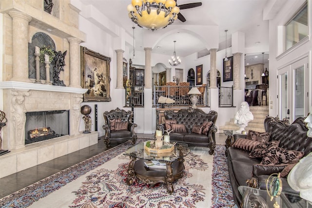 living room with ornate columns, a towering ceiling, a fireplace, and ceiling fan