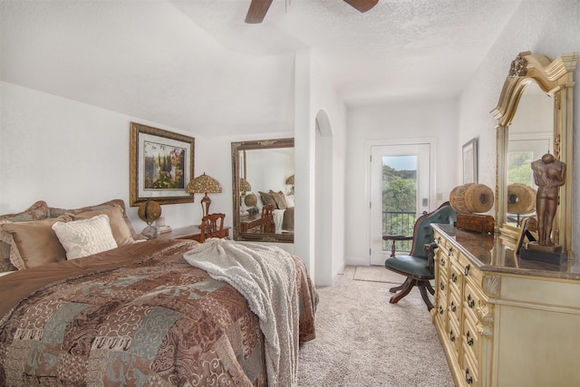 carpeted bedroom with a textured ceiling, access to exterior, and ceiling fan