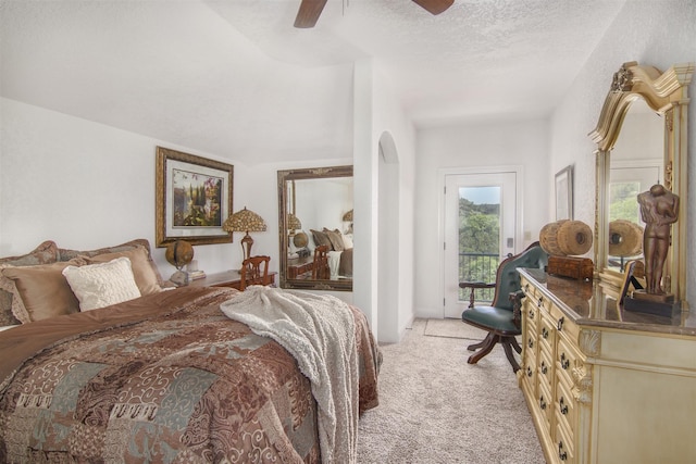 9469 Canyon Mist, Helotes, TX 78023 - bedroom with access to exterior, light carpet, arched walkways, a ceiling fan, and a textured ceiling