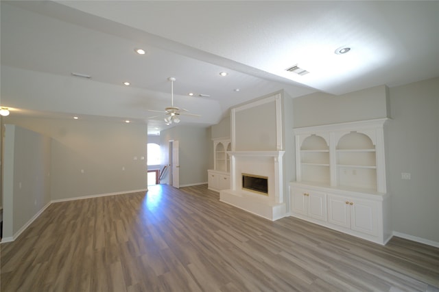 unfurnished living room with ceiling fan, hardwood / wood-style flooring, and vaulted ceiling