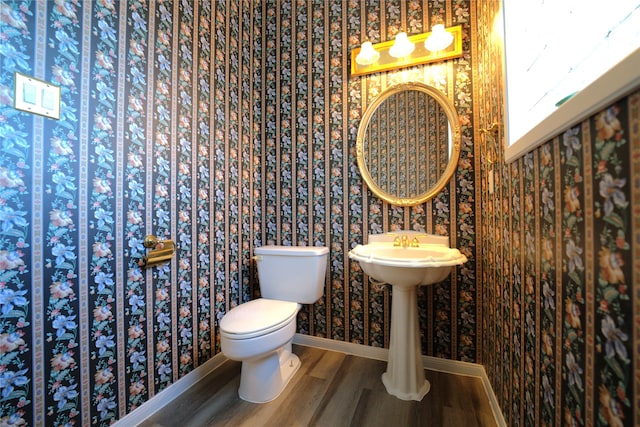 bathroom with toilet and hardwood / wood-style floors