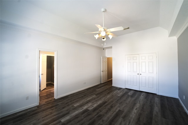 unfurnished bedroom with vaulted ceiling, dark hardwood / wood-style floors, a closet, and ceiling fan