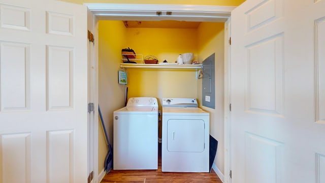 washroom featuring light hardwood / wood-style floors, electric panel, and separate washer and dryer