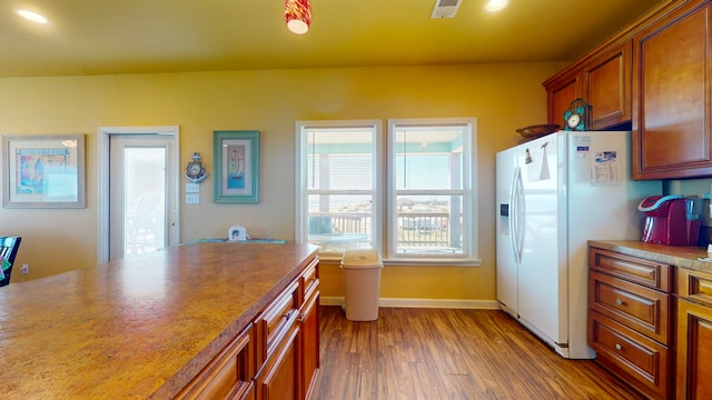 kitchen with white fridge with ice dispenser and wood-type flooring