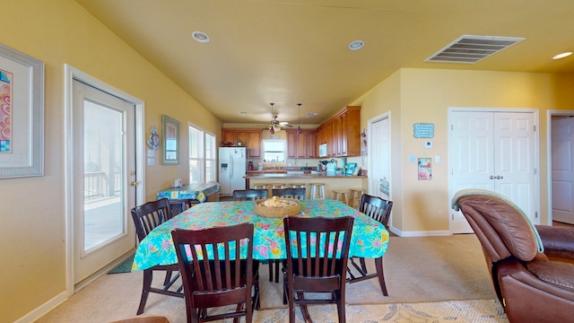 dining area featuring light colored carpet and ceiling fan