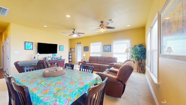 dining area with light carpet and ceiling fan