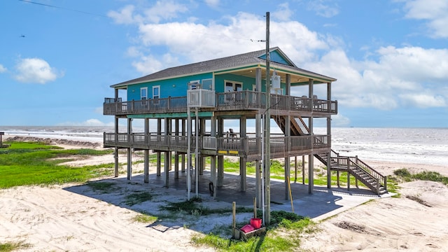 exterior space featuring a water view and a beach view