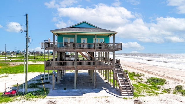 view of front of house featuring a water view, a view of the beach, and covered porch