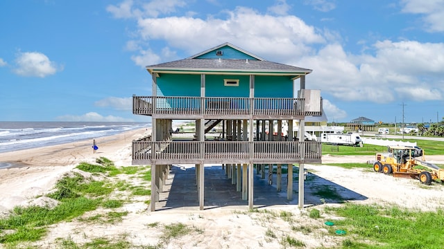 rear view of property featuring a view of the beach and a water view