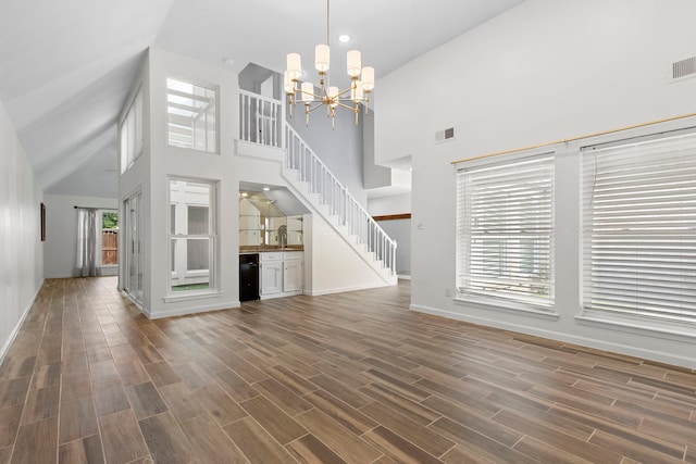 unfurnished living room featuring a high ceiling and a chandelier