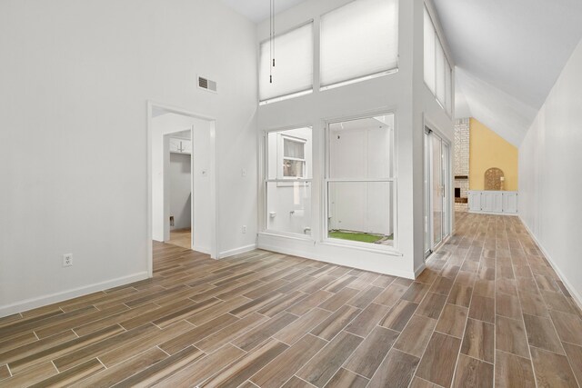 interior space featuring a towering ceiling and a brick fireplace