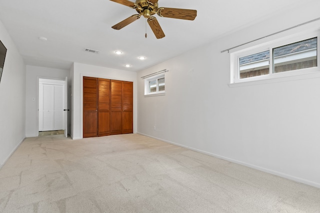 unfurnished bedroom with light colored carpet and ceiling fan