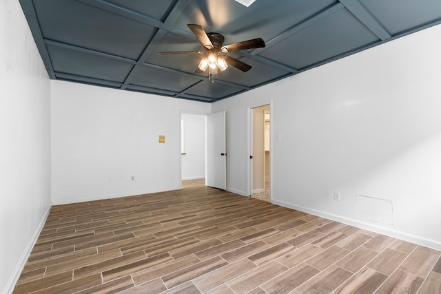 empty room featuring ceiling fan and coffered ceiling